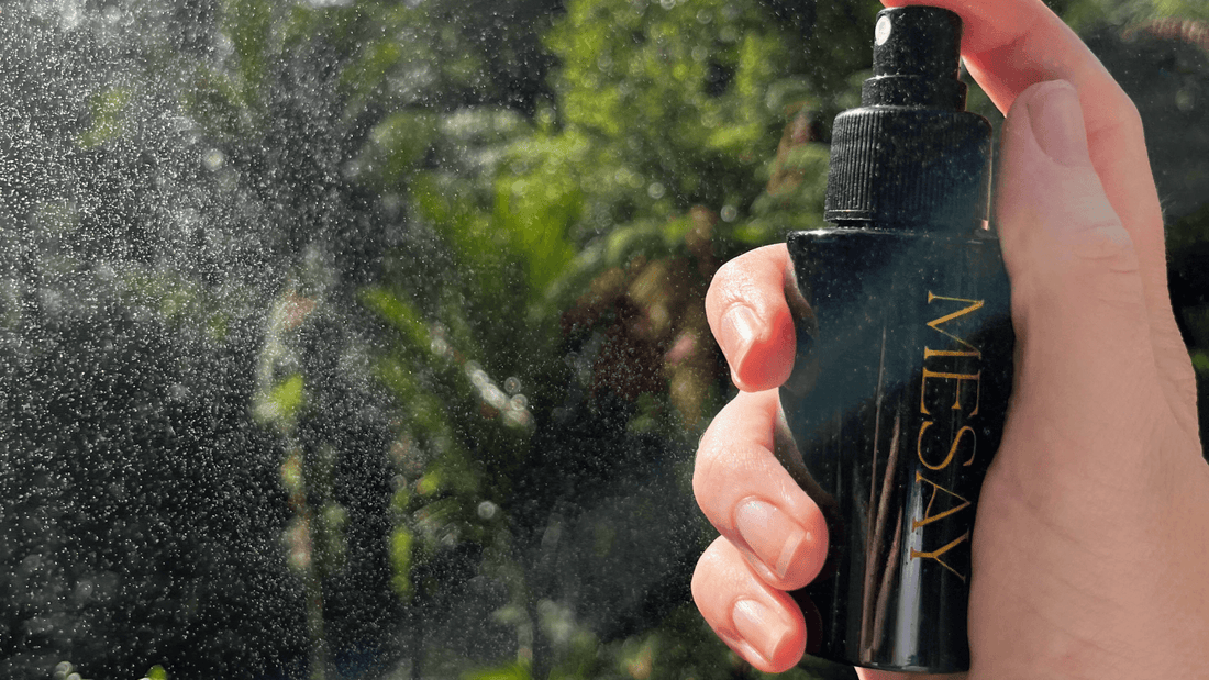 Close-up of Mesay Face Mist being spritzed from a glass bottle, releasing a fine mist into the air, highlighting its soothing and hydrating properties
